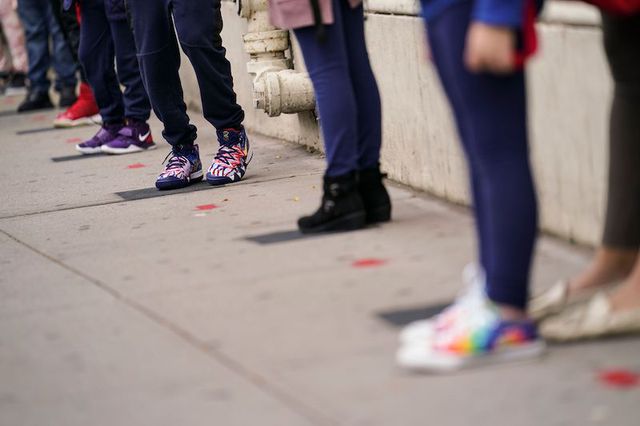 The sneakers of several students waiting at socially distanced intervals on the sidewalk outside Public School 188 The Island School in Manhattan.